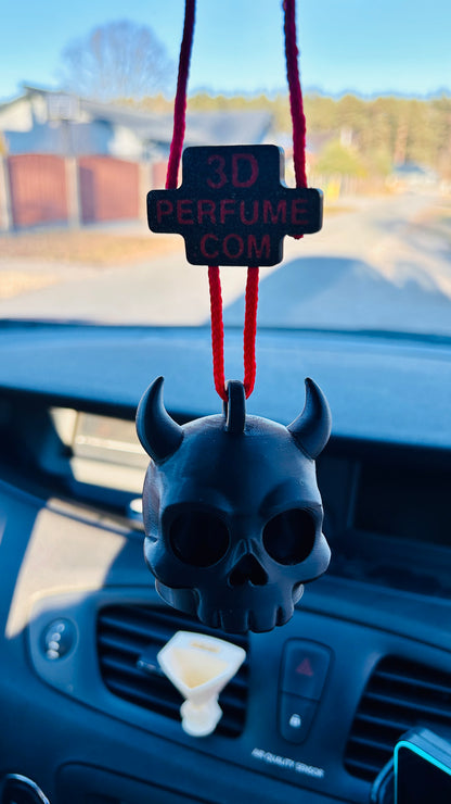 Skull-shaped car air freshener hanging from a red string on a car dashboard.