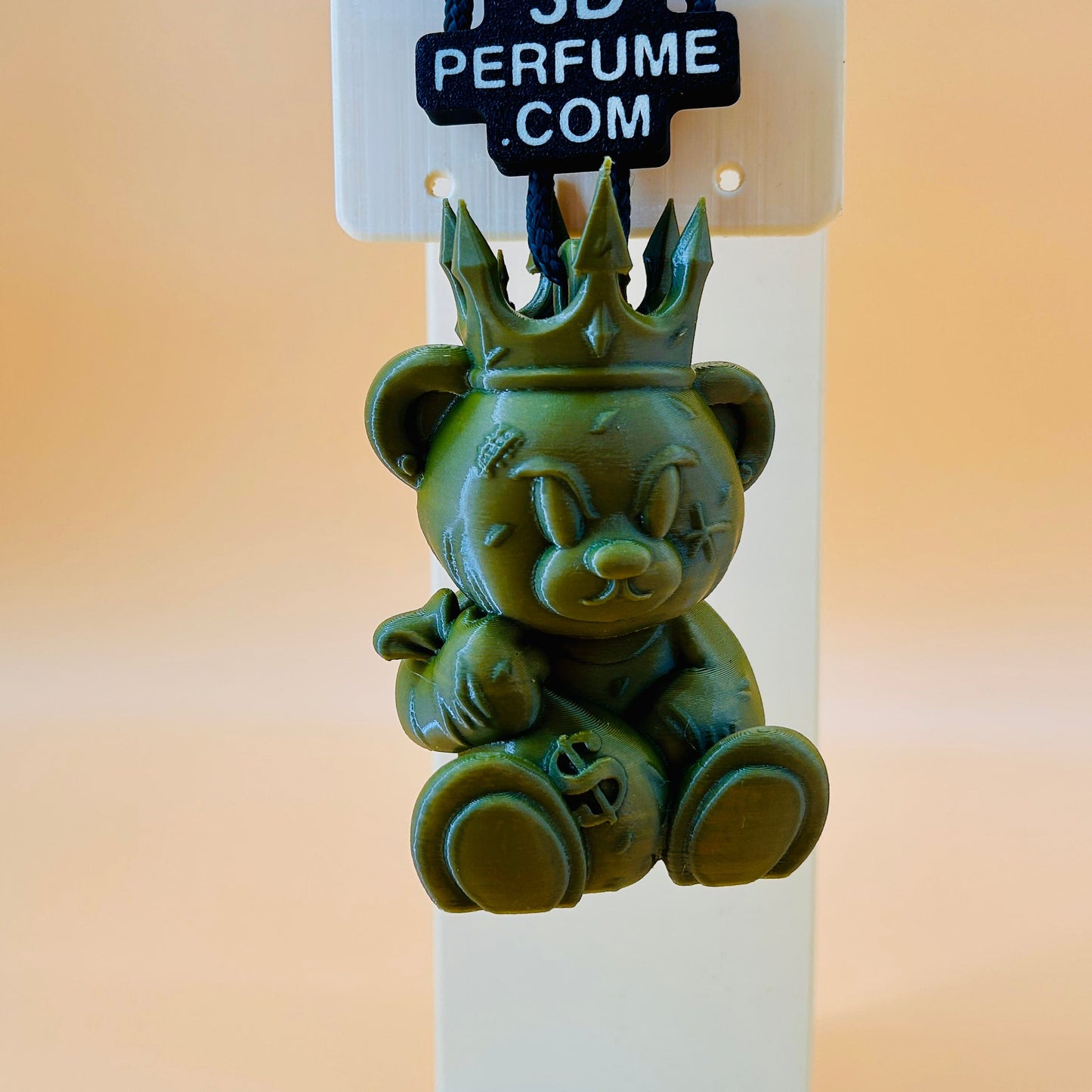 Green perfume bottle shaped like a bear with a crown on a stand, branded '3D Perfume'.