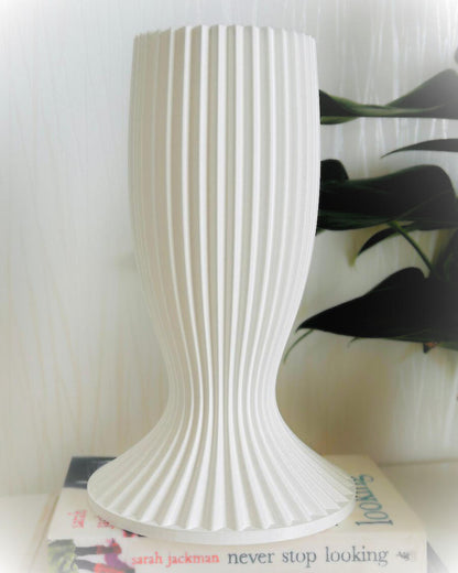 White textured vase on a surface with a blurred background