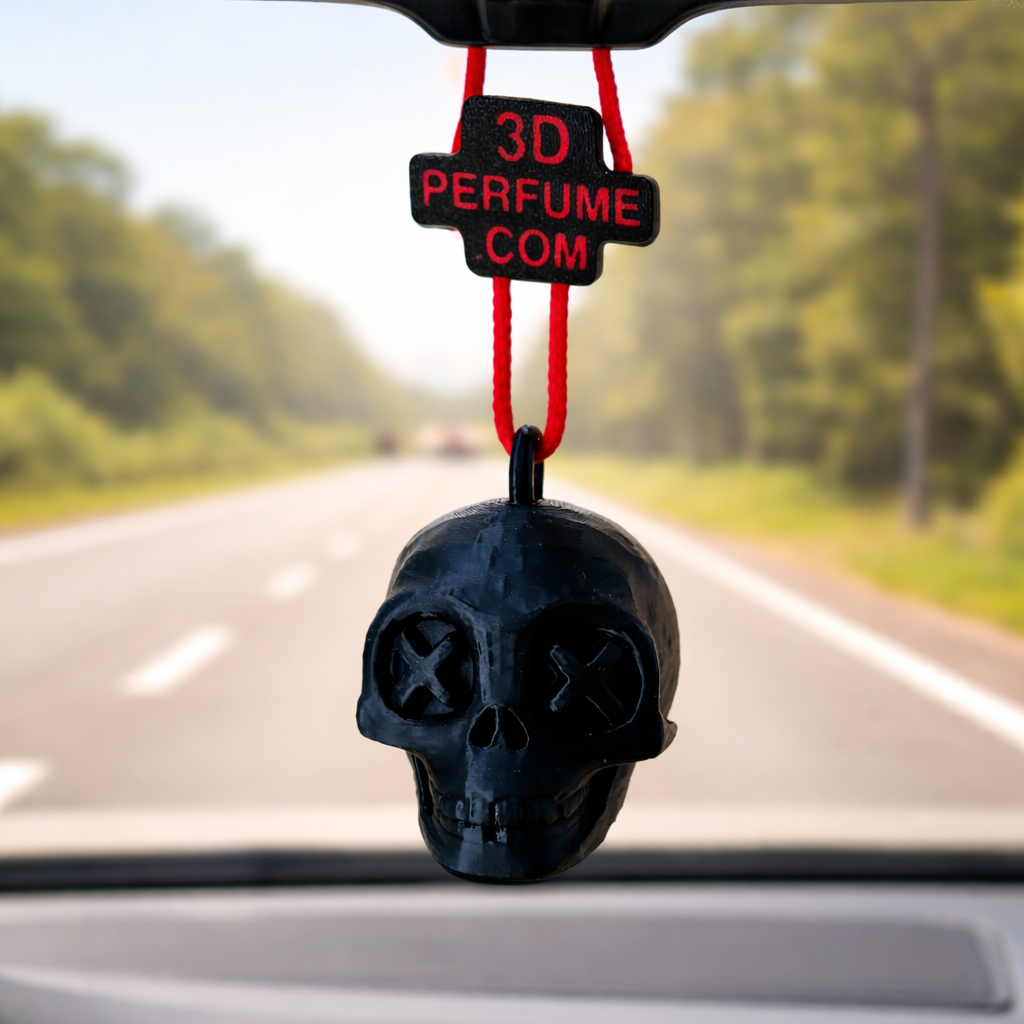 Black skull-shaped car air freshener with '3D Perfume Com' label hanging from a car's rearview mirror.